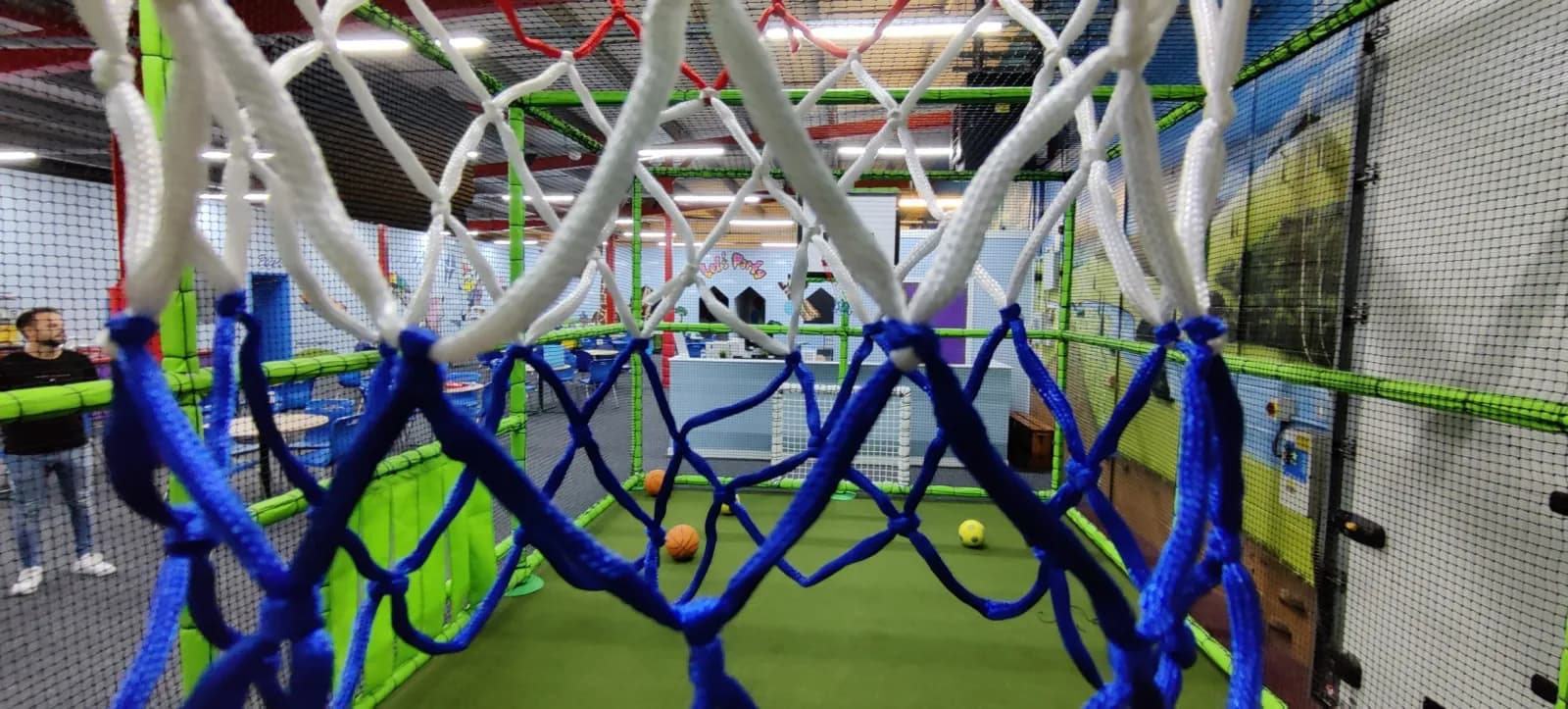 A basketball hoop and climbing nets inside the Sports Arena