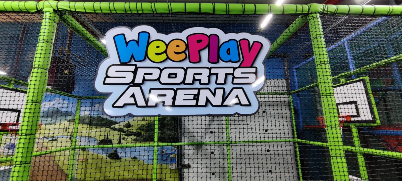 The illuminated WeePlay Sports Arena sign above the pitch