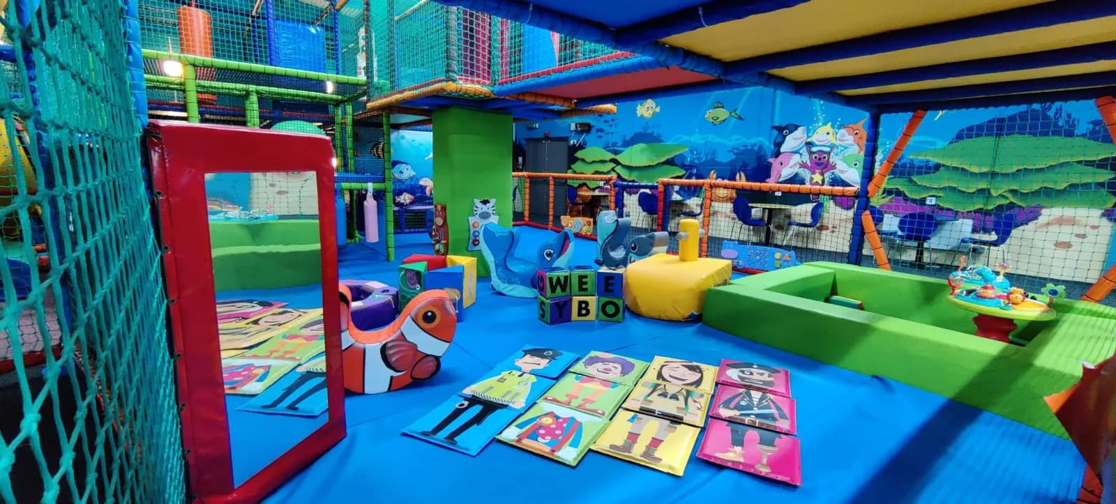 Toddler and baby soft play area with soft play mats, a mirror and jungle wall murals